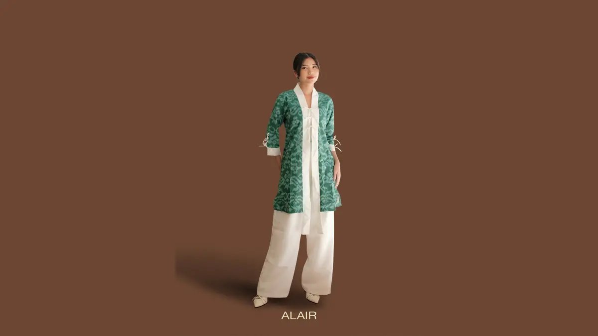 Model memakai kimono tenun hijau dengan bawahan putih sebagai outer