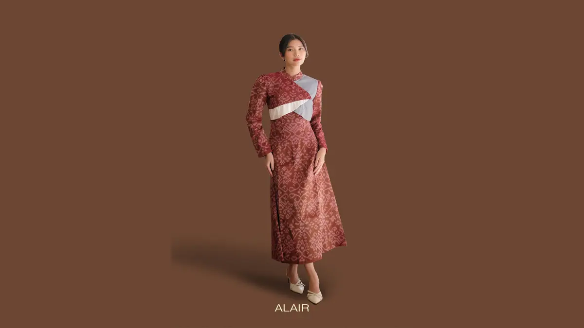 Model memakai setelan blazer dan rok tenun berwarna maroon untuk ke kantor